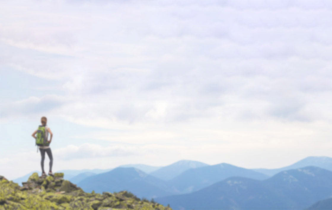 A young woman hiking a scenic view with her backpack